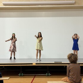 trois élèves sur une scène qui dansent